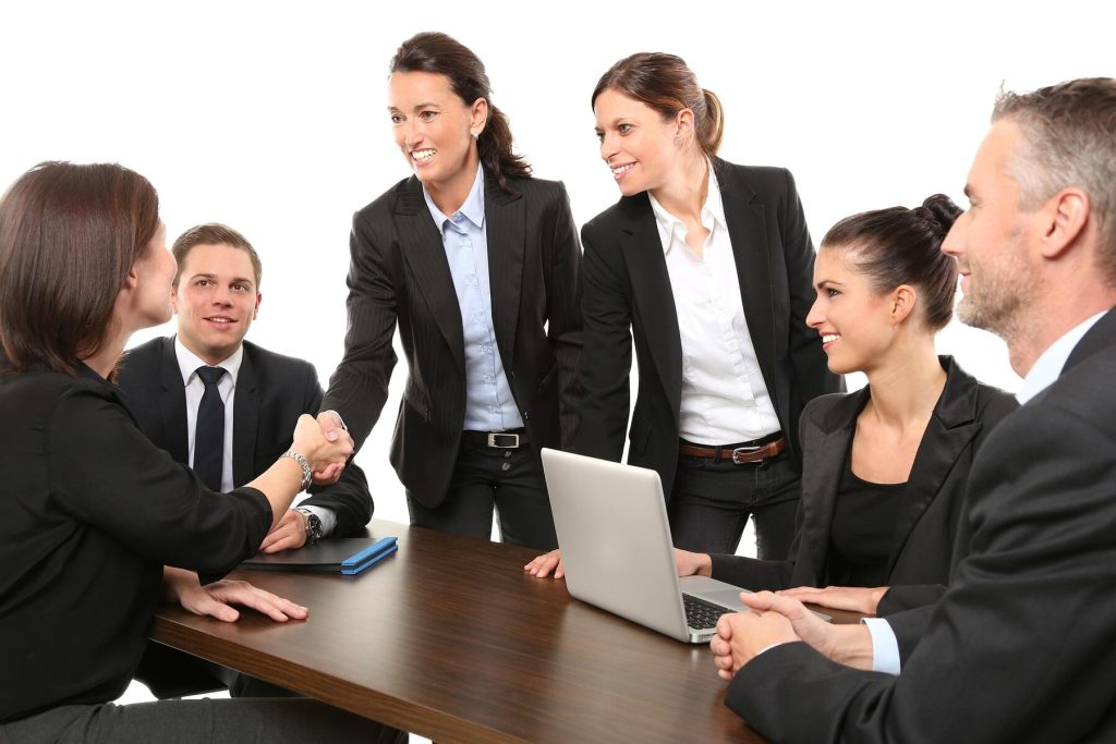 A group of professionals in business attire shaking hands during a meeting